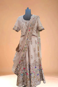 Beige embroidered lehenga with floral motifs and matching dupatta on mannequin