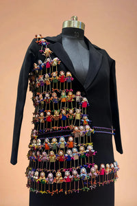 Black designer blazer with vibrant handcrafted doll embroidery, displayed on mannequin