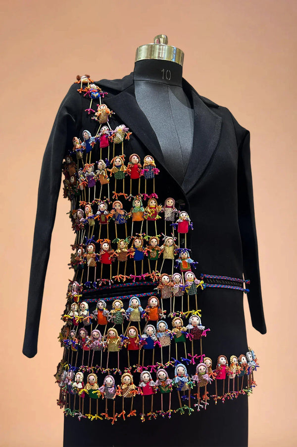 Black designer blazer with vibrant handcrafted doll embroidery, displayed on mannequin