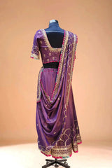 Purple designer lehenga with gold embroidery and dupatta displayed on mannequin