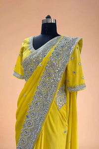 Yellow designer saree with silver sequin embroidery on a mannequin, traditional Indian attire