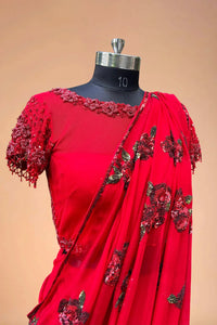Red designer saree with floral sequins and embroidered blouse on mannequin