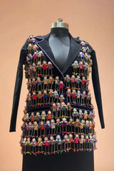 Black designer blazer with colorful handcrafted doll embellishments on mannequin