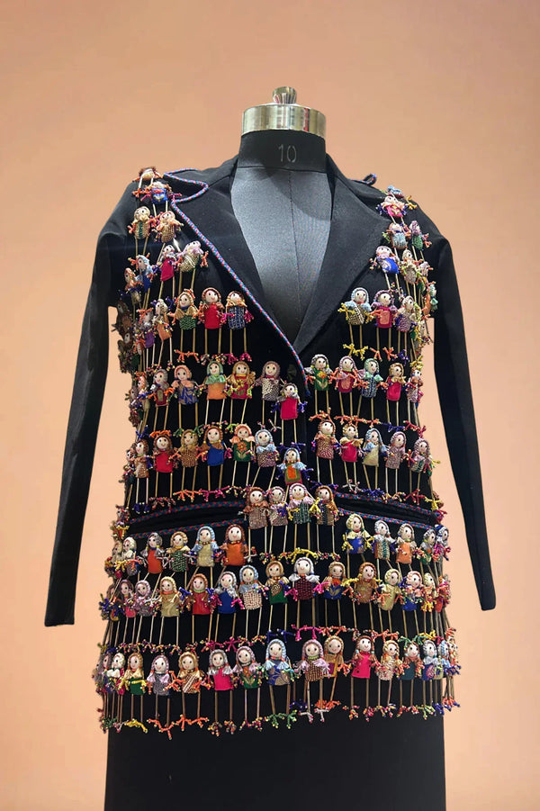 Black designer blazer with colorful handcrafted doll embellishments on mannequin
