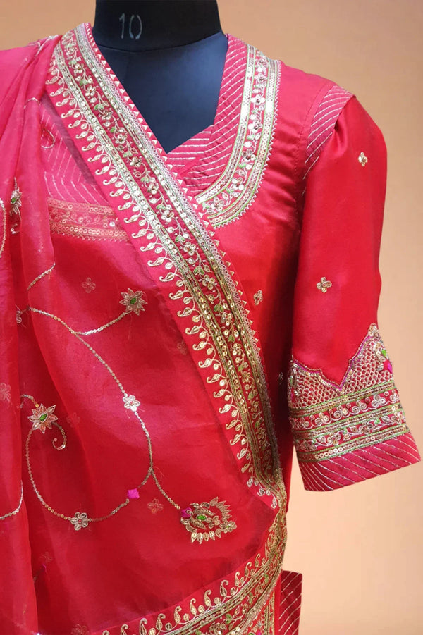 Red Indian saree with gold embroidery and floral embellishments on mannequin