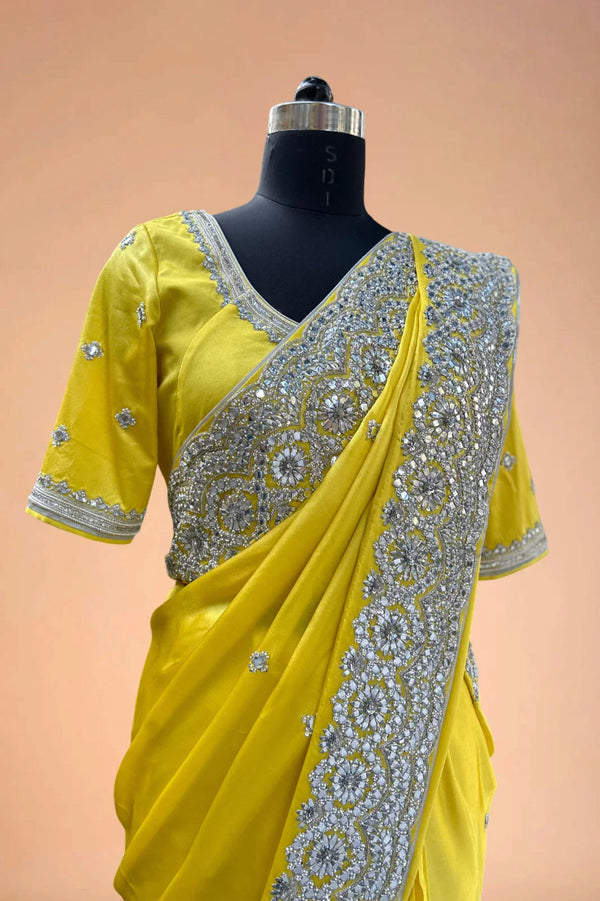 Yellow designer saree with silver sequin embroidery on blouse and border, displayed on mannequin