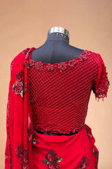 Red designer saree blouse with floral embroidery and sequin work on mannequin