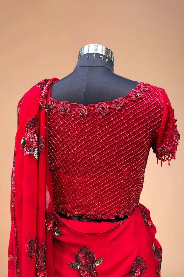 Red designer saree blouse with floral embroidery and sequin work on mannequin