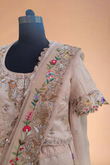 Beige embroidered Indian designer dress with floral and sequin details on a mannequin