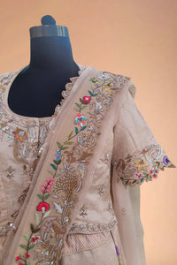 Beige embroidered Indian designer dress with floral and sequin details on a mannequin