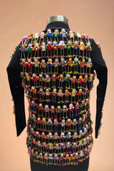 Black blazer with colorful handmade doll embellishments on the back, displayed on mannequin