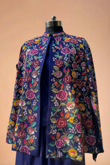 Navy blue blazer with vibrant floral embroidery, displayed on a mannequin against a beige background