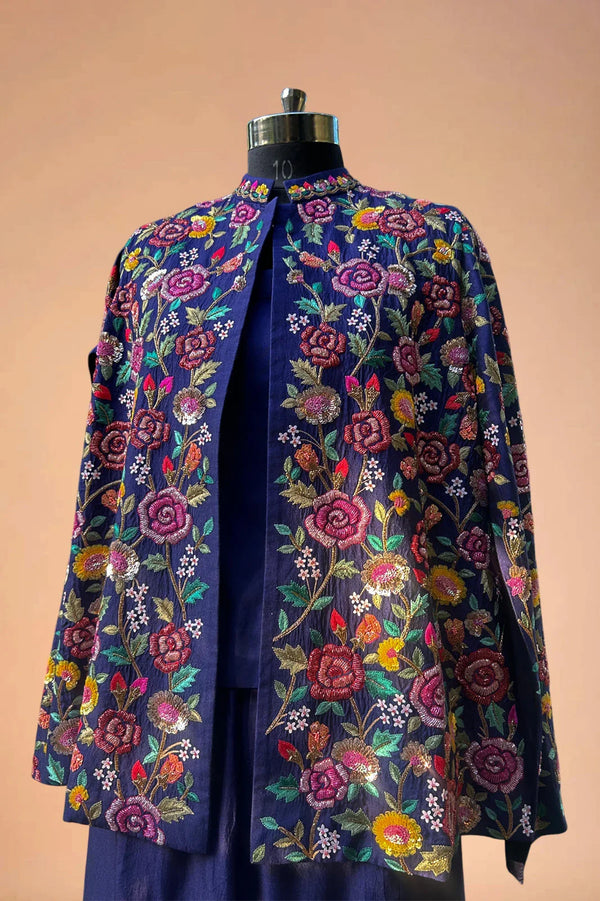 Navy blue blazer with vibrant floral embroidery, displayed on a mannequin against a beige background