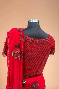 Red embroidered saree blouse with sequin floral border and matching dupatta on mannequin