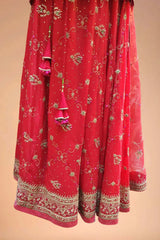 Red embroidered Indian lehenga with gold floral designs and intricate border