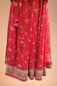 Red embroidered Indian lehenga with gold floral designs and intricate border