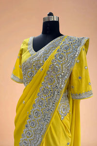 Yellow designer saree with heavy silver sequin embroidery on a mannequin, luxury ethnic wear