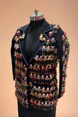 Black blazer adorned with colorful handcrafted doll embellishments on a mannequin.