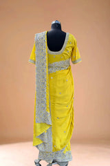 Yellow velvet saree with silver sequin embroidery on mannequin against beige background