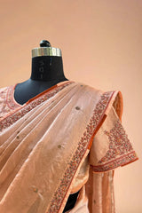 Peach silk saree with floral embroidery and matching blouse on mannequin
