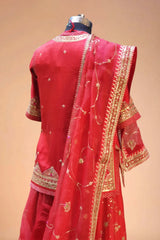 Back view of a red Indian designer lehenga with gold embroidery and net dupatta