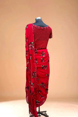 Red designer saree with sequin floral embroidery displayed on mannequin