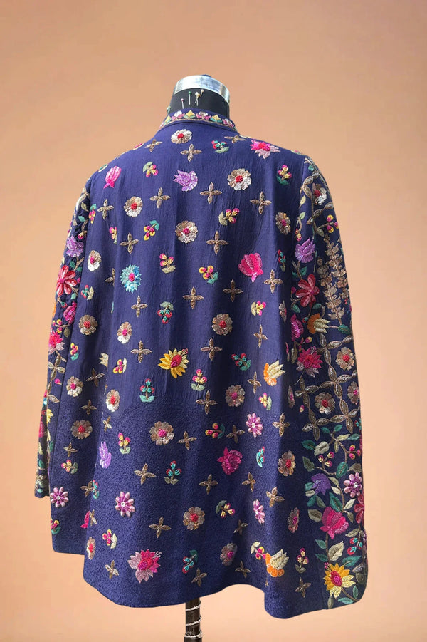 Navy blue blazer with colorful floral embroidery, displayed on a mannequin.