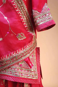 Red Indian ethnic dress with intricate gold embroidery and sequin details on silk fabric
