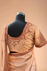 Peach silk saree with floral embroidery and matching blouse on mannequin