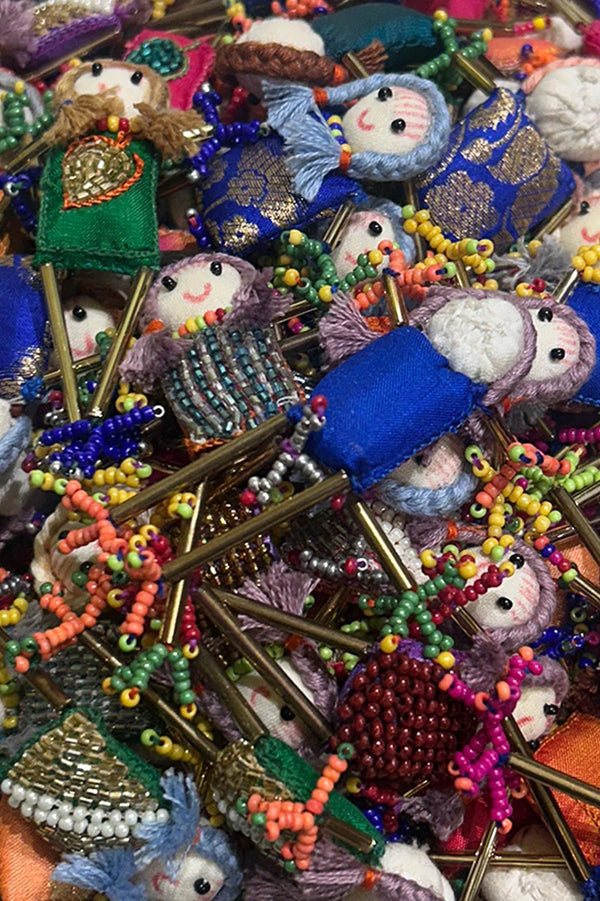 Handcrafted beaded dolls with colorful fabric dresses and intricate embroidery details