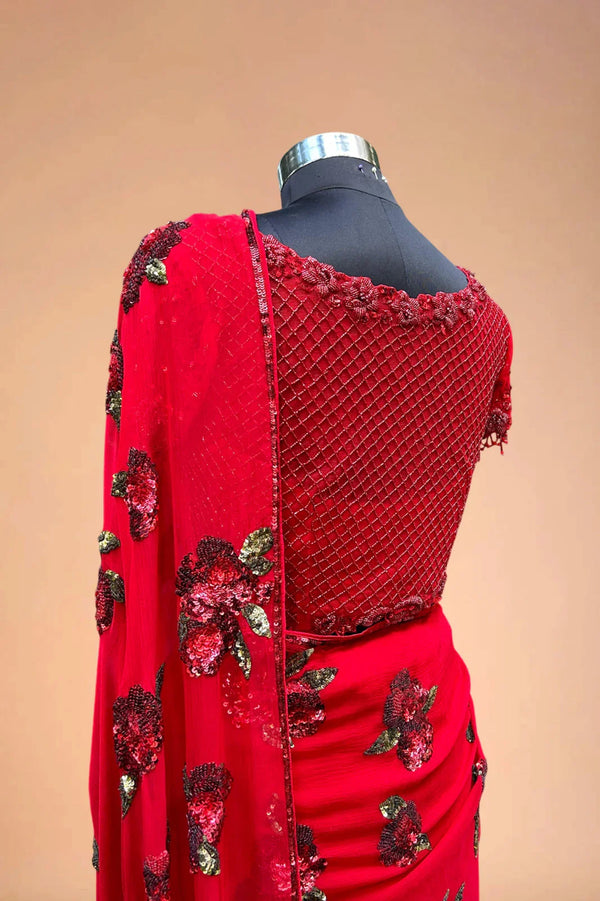 Red embroidered saree with floral sequin details and netted blouse on mannequin