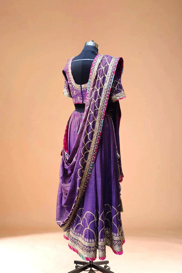 Purple Indian lehenga with gold embroidery and dupatta displayed on a mannequin