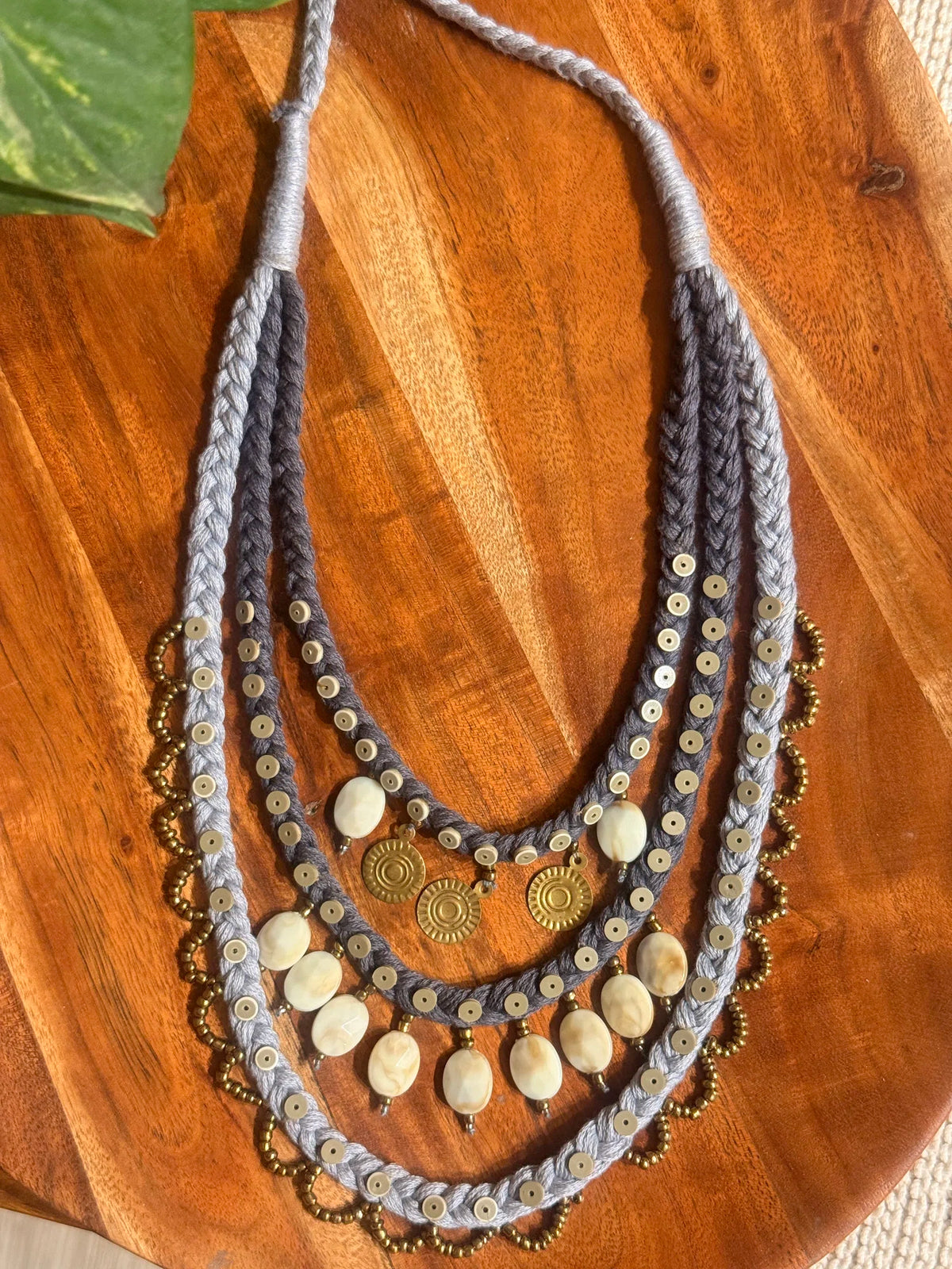 Aavartan handcrafted textile necklace layered strands laid on a wooden surface | Utsavi by Shilpa