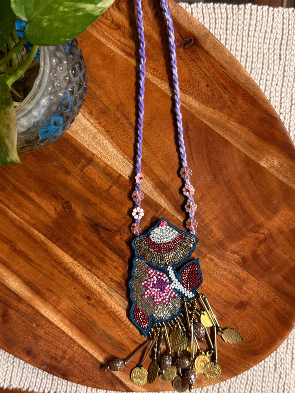 Gulistan handcrafted textile necklace embroidered pendant laid on wood | Utsavi by Shilpa