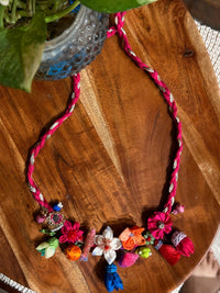 Manjari handcrafted textile necklace floral necklace arranged on wood | Utsavi by Shilpa