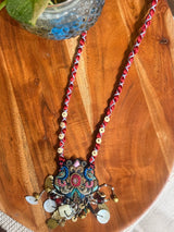 Mayur handcrafted textile necklace embroidered pendant laid on wood | Utsavi by Shilpa