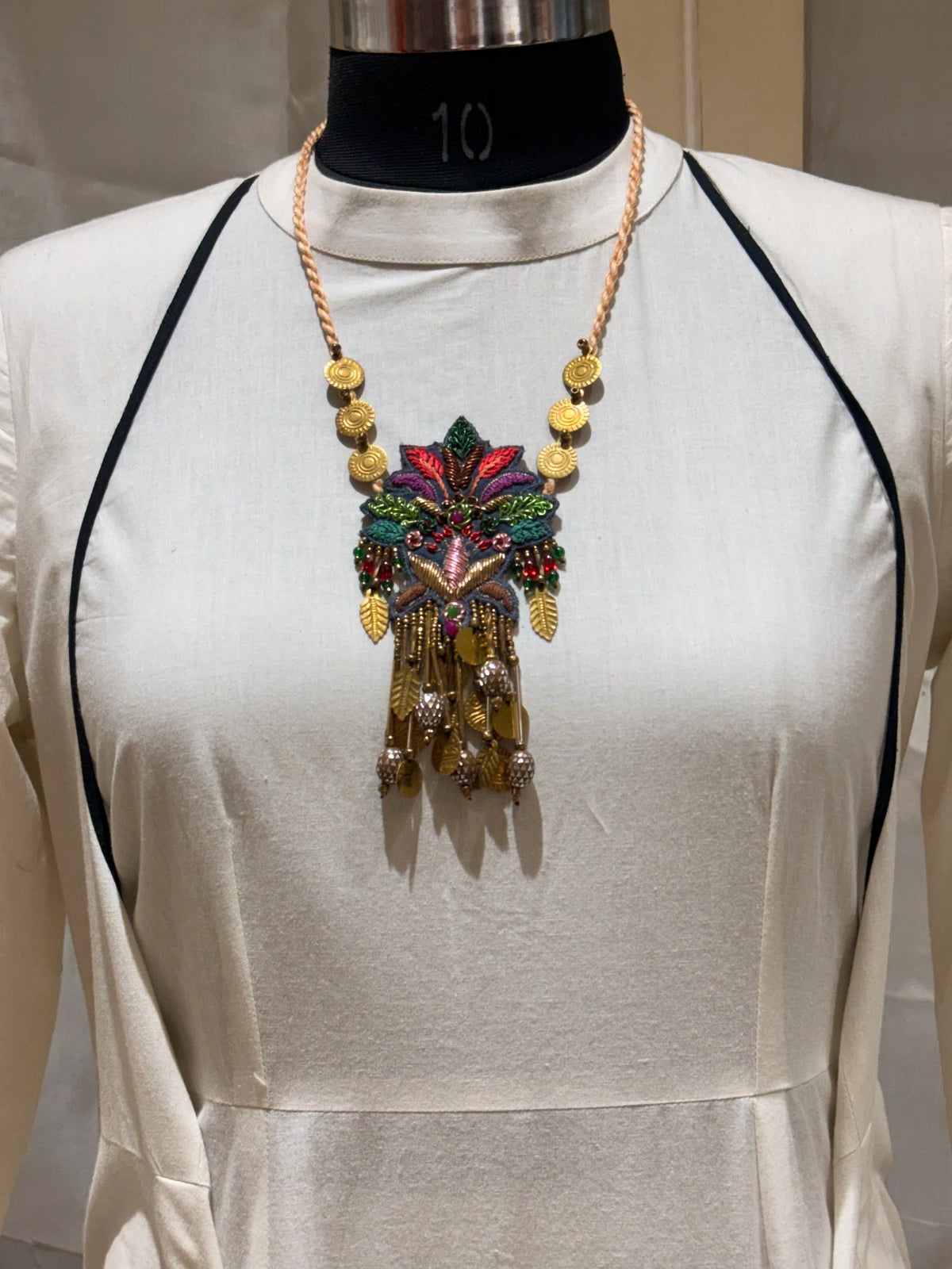 Pallava handcrafted textile necklace pendant displayed over a light garment | Utsavi by Shilpa