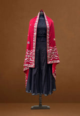 Red embroidered pashmina shawl draped over a black dress on a mannequin