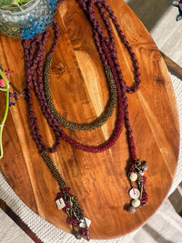 Sangati handcrafted textile necklace textile strands on a wooden surface | Utsavi by Shilpa