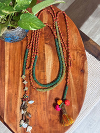 Sangati handcrafted textile necklace colourful strands laid on a wooden surface | Utsavi by Shilpa