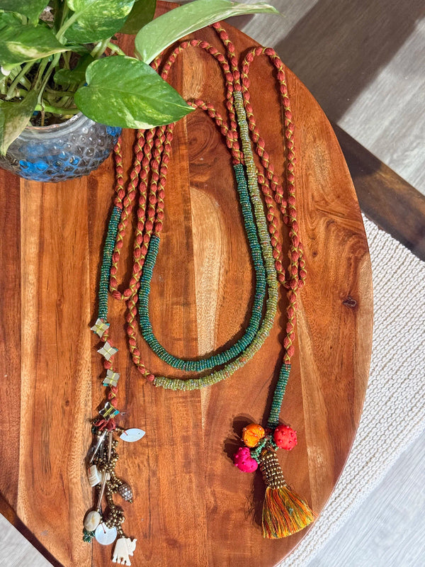 Sangati handcrafted textile necklace colourful strands laid on a wooden surface | Utsavi by Shilpa