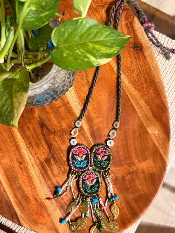 Triveni handcrafted textile necklace floral motifs laid on a wooden surface | Utsavi by Shilpa