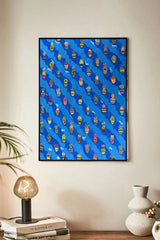 Framed artwork with a blue background and colorful pattern on a wall above a shelf.